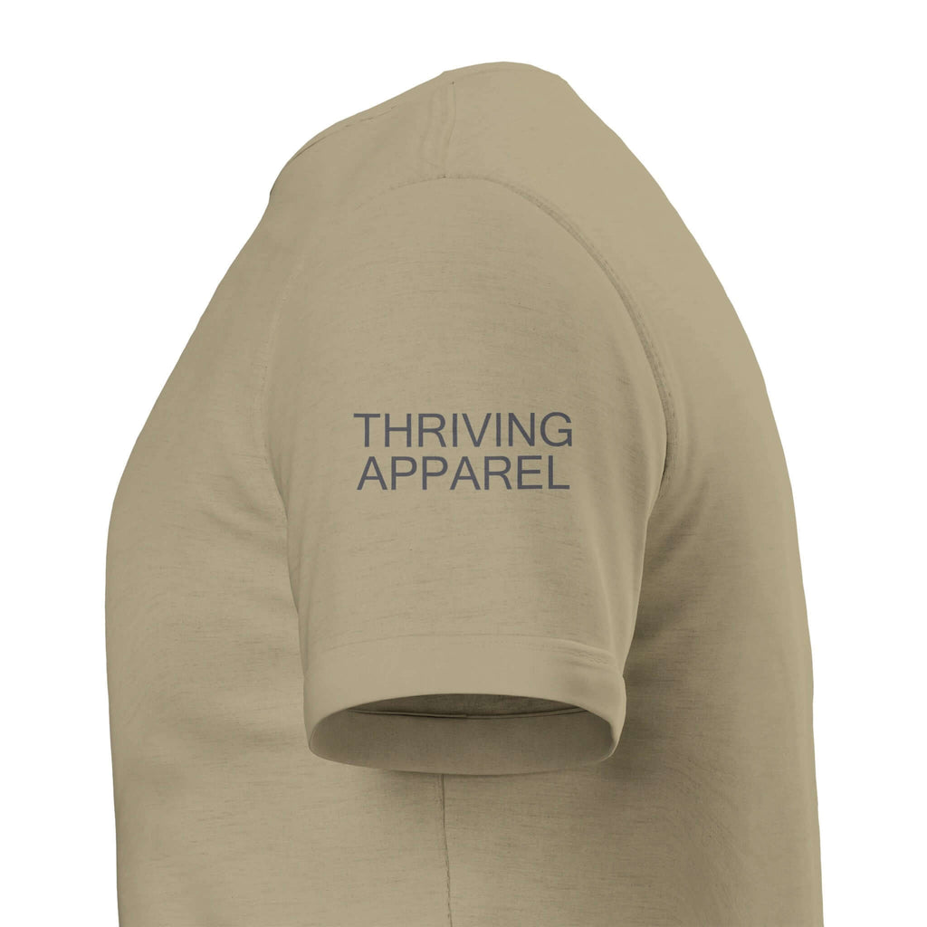 Close-up of beige Thriving Apparel t-shirt sleeve with logo.