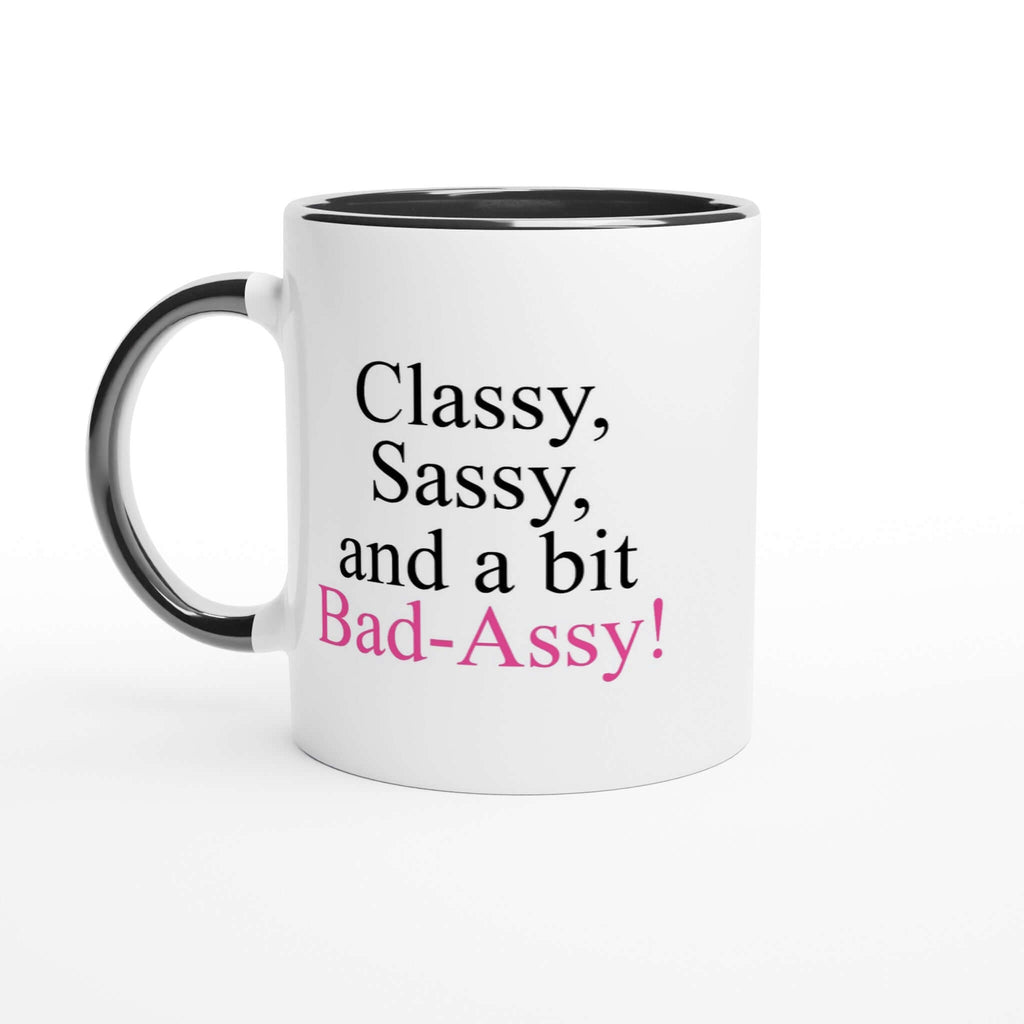 Ceramic 11oz mug with the phrase "Classy, Sassy, and a bit Bad-Assy" in black and pink on a white print area with black rim and handle.