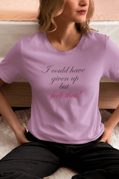 Woman wearing a pink fitted premium tee with "I could have given up but fuck that!" in cursive, symbolizing resilience and empowerment.